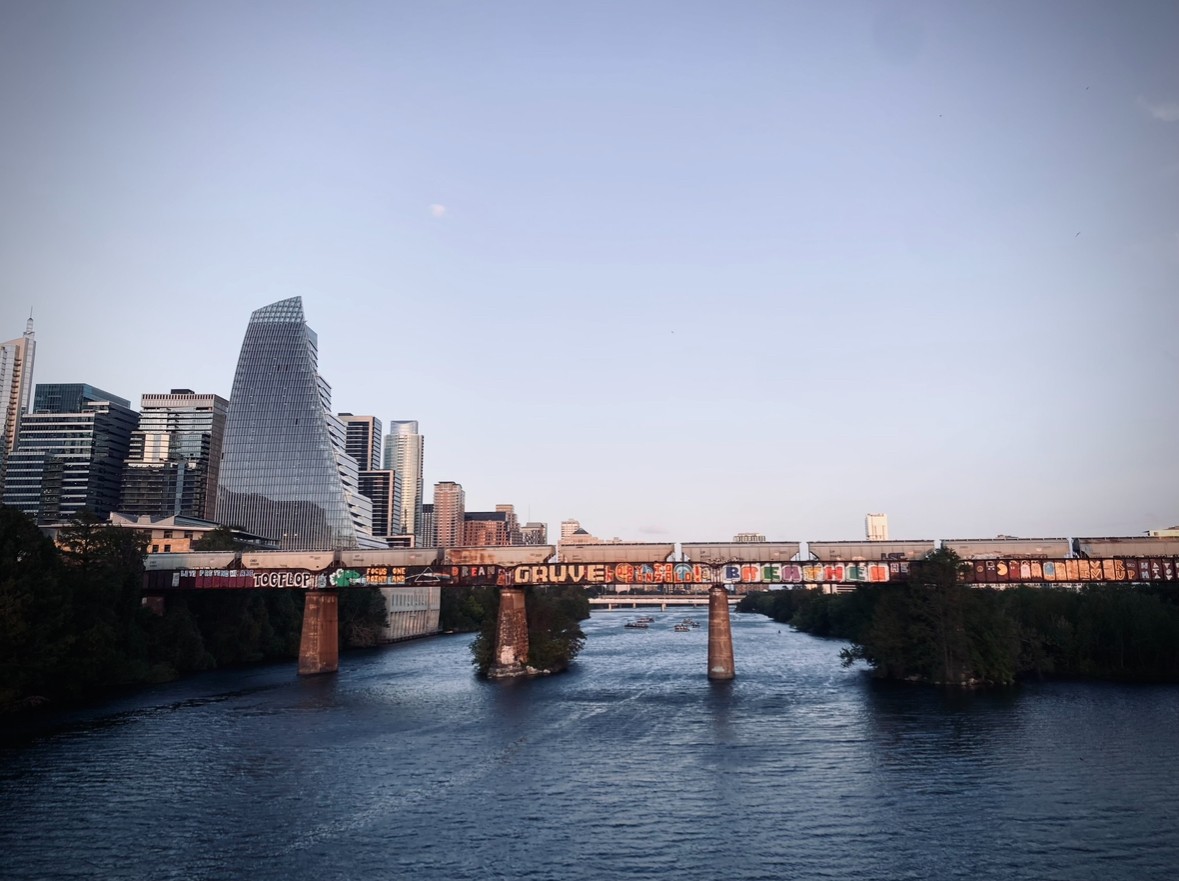 Railroad bridge over Lady Bird Lake with the Austin skyline